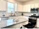 Bright kitchen features granite counters, white cabinets, stainless appliances, and kitchen island at 7024 Wheyfield Dr, Charlotte, NC 28215