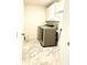 Well-lit laundry room boasts modern washer and dryer with cabinets for storage space and marble-look floors at 7024 Wheyfield Dr, Charlotte, NC 28215