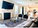 Cozy living room with a fireplace, mounted TV, and open layout to the adjacent kitchen at 7024 Wheyfield Dr, Charlotte, NC 28215