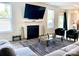 Bright living room with fireplace, mounted TV, and ample natural light from the nearby windows at 7024 Wheyfield Dr, Charlotte, NC 28215