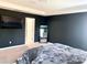 Spacious main bedroom with a dark accent wall, sleek TV, and plush platform bed at 7024 Wheyfield Dr, Charlotte, NC 28215