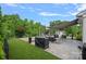 A serene backyard featuring an outdoor dining and entertaining space with artificial turf and mature trees at 7331 Millstone Sw Cir, Concord, NC 28025