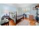 Serene bedroom featuring hardwood floors, shuttered windows, a comfortable bed, and stylish decor, creating a relaxing and inviting retreat at 800 Davenport St, Monroe, NC 28112