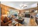 Spacious living room featuring wood paneling, fireplace, a ceiling fan, and comfortable seating, creating a cozy and inviting atmosphere at 800 Davenport St, Monroe, NC 28112