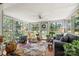 Bright sunroom with abundant natural light, multiple windows, plants, comfortable seating creating a serene and relaxing space at 800 Davenport St, Monroe, NC 28112