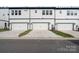 Modern townhome garages with white doors, clean lines, and well-maintained driveways and landscaping at 8928 Morning Mist Rd, Charlotte, NC 28215