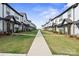 Exterior view of a sidewalk and townhomes featuring white siding and black window trim at 8928 Morning Mist Rd, Charlotte, NC 28215