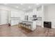 Kitchen features white cabinetry, stainless appliances, an island with seating, and LVP flooring at 8928 Morning Mist Rd, Charlotte, NC 28215