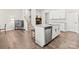Bright kitchen island with granite countertop, sink, stainless dishwasher, and seating faces stairs and a living area at 8928 Morning Mist Rd, Charlotte, NC 28215