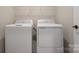 Laundry room featuring a new white washer and dryer and a wire shelf above at 8928 Morning Mist Rd, Charlotte, NC 28215