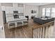 Open-concept living room with kitchen island and counter seating, plus a sectional and large windows at 8928 Morning Mist Rd, Charlotte, NC 28215