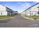 Street view of new townhomes with garages, showcasing a modern community streetscape at 8928 Morning Mist Rd, Charlotte, NC 28215