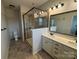 Bathroom featuring double sinks, quartz countertop, walk-in shower with glass door, and tile flooring at 9236 Ainslie Downs St, Charlotte, NC 28273