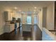 Open concept kitchen with stainless steel appliances, kitchen island and dark hardwood floors throughout at 9236 Ainslie Downs St, Charlotte, NC 28273