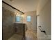 Walk-in shower with glass door, shower caddy, and tile flooring at 9236 Ainslie Downs St, Charlotte, NC 28273
