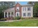 Charming two-story home with brick accents, a covered front porch, and well-maintained landscaping at 134 Lake Spring Loop, Mooresville, NC 28117
