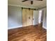Cozy bedroom featuring hardwood floors and a unique wooden barn door-style closet at 410 Gann St, Lowell, NC 28098