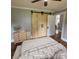 Bright bedroom featuring wood sliding doors, light dresser, and hardwood floors at 410 Gann St, Lowell, NC 28098