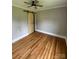 Bedroom featuring hardwood floors, a ceiling fan, and a unique wooden barn door-style closet at 410 Gann St, Lowell, NC 28098