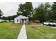 Charming single-story home with a well-maintained lawn, walkway, front porch, and flag at 410 Gann St, Lowell, NC 28098