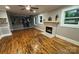 Bright living room with hardwood floors, a brick fireplace, and a view of the kitchen at 410 Gann St, Lowell, NC 28098