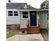 Back door and access to basement with wood stairs, gray siding, and updated windows at 410 Gann St, Lowell, NC 28098