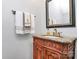 Elegant powder room featuring a carved wood vanity with marble top and decorative mirror at 7023 Blakeney Greens Blvd, Charlotte, NC 28277