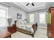 Bright bedroom with tray ceiling, fan, two windows, and a well-coordinated brown and teal color scheme at 7023 Blakeney Greens Blvd, Charlotte, NC 28277