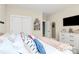 Bright bedroom with white walls, a full bed, a white dresser, and two white doors at 7023 Blakeney Greens Blvd, Charlotte, NC 28277