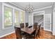 Formal dining room showcasing hardwood floors, modern chandelier, and ample natural light from the windows at 7023 Blakeney Greens Blvd, Charlotte, NC 28277