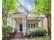 Charming home featuring a covered front porch, brick stairs, and meticulously maintained landscaping at 7023 Blakeney Greens Blvd, Charlotte, NC 28277