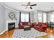 Cozy living room features a fireplace, hardwood floors, and a ceiling fan at 7023 Blakeney Greens Blvd, Charlotte, NC 28277