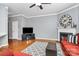 Open living room with hardwood floors, fireplace, and large screen TV at 7023 Blakeney Greens Blvd, Charlotte, NC 28277