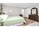 Comfortable bedroom features modern decor, a light green bedspread and wood laminate flooring at 10024 Tealridge Ln, Charlotte, NC 28277