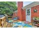 Inviting outdoor deck with seating, rug, and a red brick chimney, perfect for relaxing at 10024 Tealridge Ln, Charlotte, NC 28277