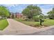 Brick home with a long driveway, beautiful lawn, and professional landscaping, with mature shade tree at 10024 Tealridge Ln, Charlotte, NC 28277
