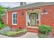 Charming red brick home with a welcoming front door, address number, and beautiful landscaping at 10024 Tealridge Ln, Charlotte, NC 28277
