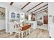 Cozy kitchen featuring white cabinets, wood beams, and an attached breakfast nook and laundry area at 10024 Tealridge Ln, Charlotte, NC 28277