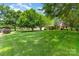 Expansive front lawn and mature trees surrounding a tan home at 1012 Lightwood Dr, Matthews, NC 28105
