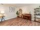 Inviting living room featuring hardwood floors, piano, and decorative shelving at 1012 Lightwood Dr, Matthews, NC 28105