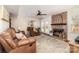 Cozy living room with a brick fireplace, ceiling fan, and plush leather seating arrangement at 1012 Lightwood Dr, Matthews, NC 28105
