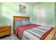 Light filled bedroom featuring wood frame bed, light green walls, and wood-look floors at 1017 Quail Run Ct, Indian Land, SC 29707