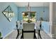 Bright dining room featuring light blue walls, and a table overlooking the landscaped backyard at 1017 Quail Run Ct, Indian Land, SC 29707