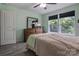A bedroom with light green walls, wood floors, and natural light from two windows at 1017 Quail Run Ct, Indian Land, SC 29707