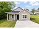 Charming single-story home with light tan siding, white trim, covered porch, and a well-maintained front lawn at 104 E Louisiana Ave, Bessemer City, NC 28016