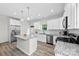 Stylish kitchen with white cabinets, stainless steel appliances, an island, and a view to a backyard door and window at 104 E Louisiana Ave, Bessemer City, NC 28016