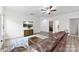 Well-lit living room with hardwood floors, comfortable seating, a modern ceiling fan, and calming white walls at 104 E Louisiana Ave, Bessemer City, NC 28016