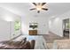 Spacious living area offers neutral walls, sleek ceiling fan, wood floors, and a TV for cozy entertainment at 104 E Louisiana Ave, Bessemer City, NC 28016