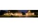 Exterior view of a beautiful home with well-lit garages, trees and long driveway at twilight at 109 Oak Forest Dr, Kings Mountain, NC 28086