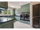 Well-organized laundry room with built-in cabinets, granite countertops and modern washer/dryer at 109 Oak Forest Dr, Kings Mountain, NC 28086